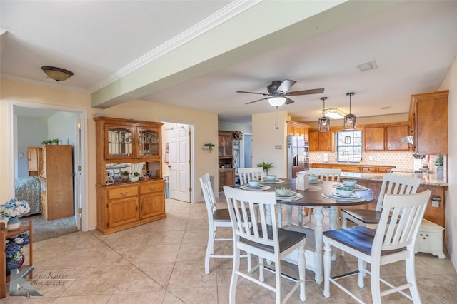 tiled dining room featuring ceiling fan, ornamental molding, and sink