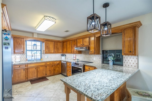 kitchen featuring sink, hanging light fixtures, appliances with stainless steel finishes, a kitchen breakfast bar, and kitchen peninsula