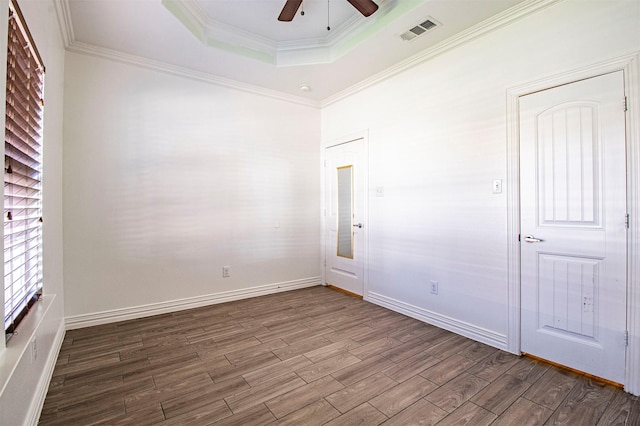 unfurnished room featuring hardwood / wood-style flooring, ceiling fan, ornamental molding, and a raised ceiling