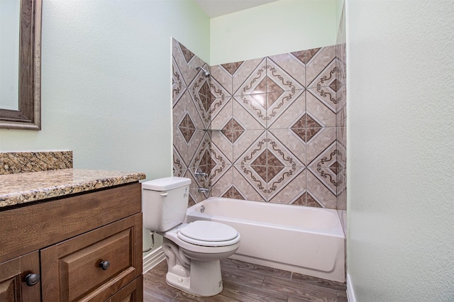 full bathroom with hardwood / wood-style flooring, vanity, tiled shower / bath, and toilet