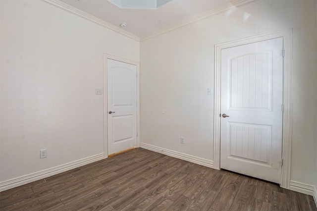 empty room with ornamental molding and dark wood-type flooring