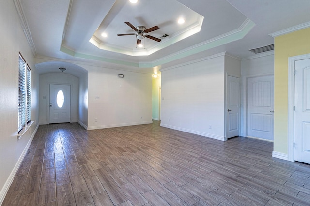 interior space with crown molding, ceiling fan, a tray ceiling, and light hardwood / wood-style flooring