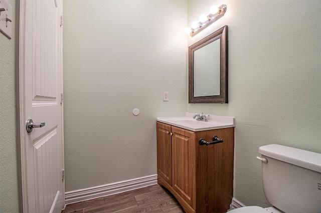 bathroom featuring vanity, hardwood / wood-style floors, and toilet