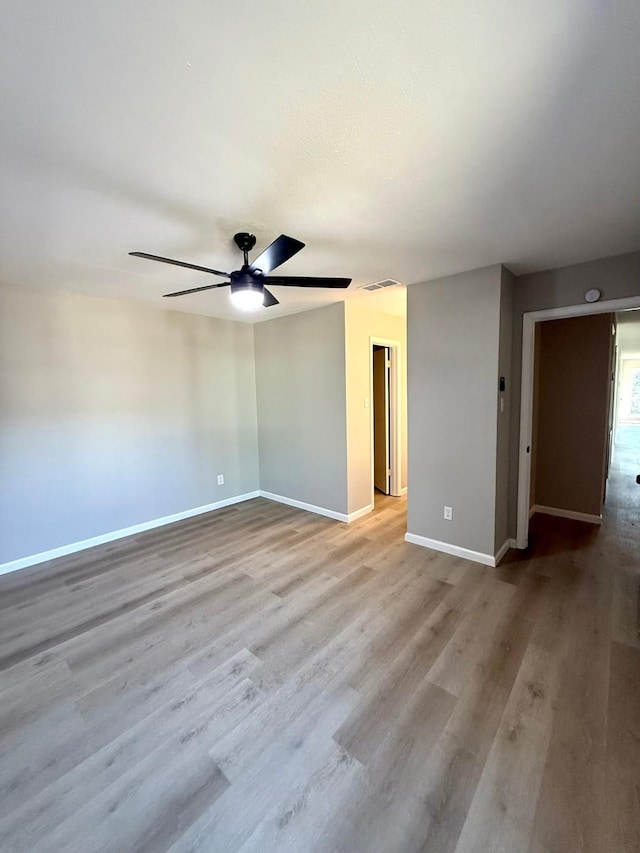 unfurnished room with ceiling fan and light wood-type flooring