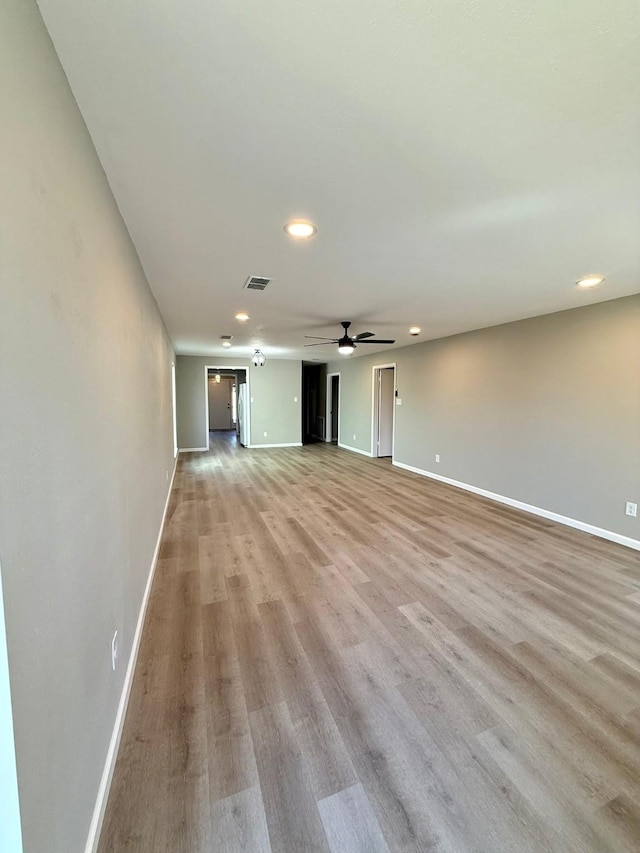 unfurnished living room with ceiling fan and light hardwood / wood-style flooring