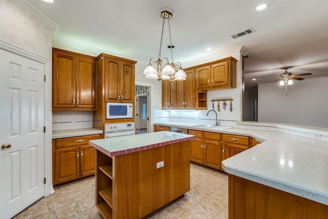 kitchen featuring pendant lighting, sink, a center island, kitchen peninsula, and white appliances