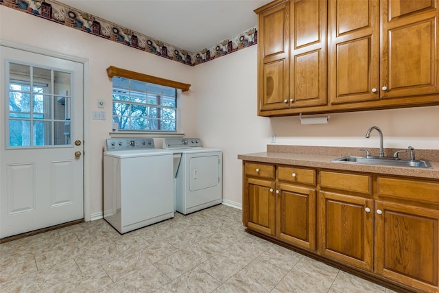 laundry area featuring cabinets, washing machine and clothes dryer, and sink