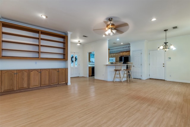 unfurnished living room featuring crown molding, ceiling fan with notable chandelier, and light hardwood / wood-style flooring