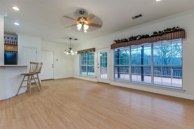 living room with crown molding, ceiling fan with notable chandelier, and light hardwood / wood-style floors