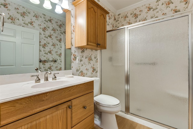 bathroom featuring vanity, crown molding, a shower with shower door, and toilet