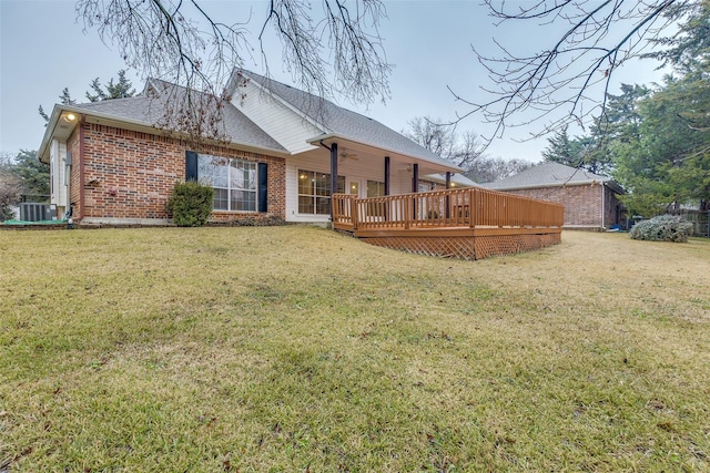 rear view of house with a yard, central AC, and a deck