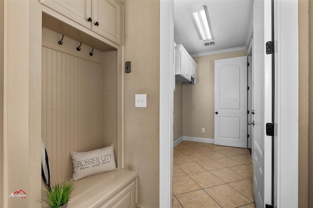 mudroom with light tile patterned floors and crown molding