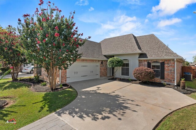 view of front of house with a garage, cooling unit, and a front lawn