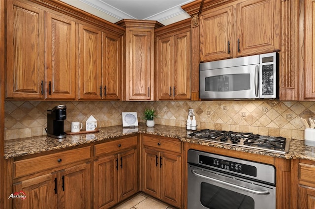 kitchen featuring tasteful backsplash, crown molding, appliances with stainless steel finishes, and dark stone counters