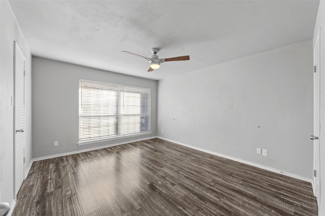 empty room with dark hardwood / wood-style flooring, ceiling fan, and a textured ceiling