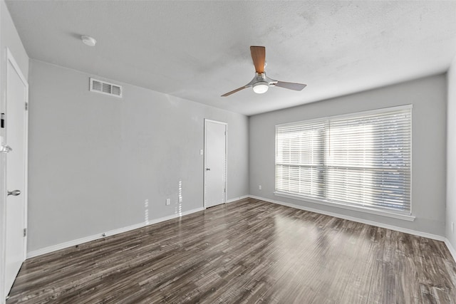 unfurnished room with dark hardwood / wood-style flooring, a textured ceiling, and ceiling fan