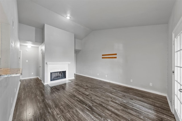 unfurnished living room with dark wood-type flooring and vaulted ceiling