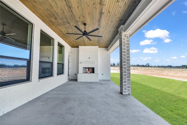 view of patio / terrace with an outdoor brick fireplace, a rural view, and ceiling fan