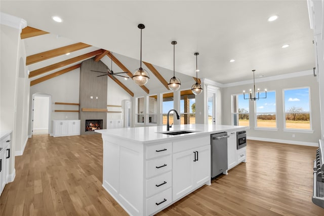 kitchen with pendant lighting, sink, a kitchen island with sink, white cabinetry, and stainless steel dishwasher