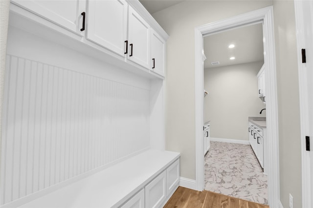 mudroom with sink and light hardwood / wood-style flooring