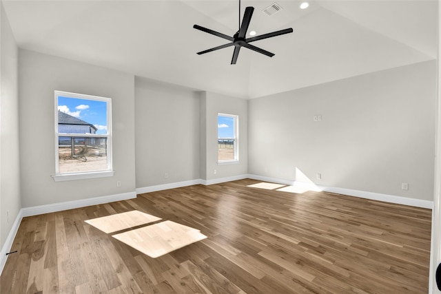 spare room with hardwood / wood-style flooring, vaulted ceiling, and ceiling fan