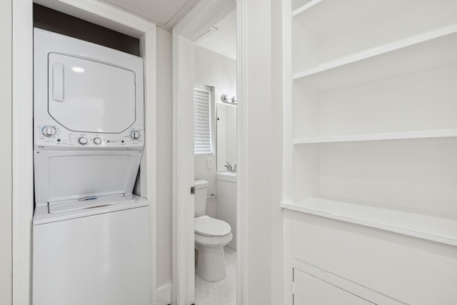 bathroom with stacked washer and dryer and toilet