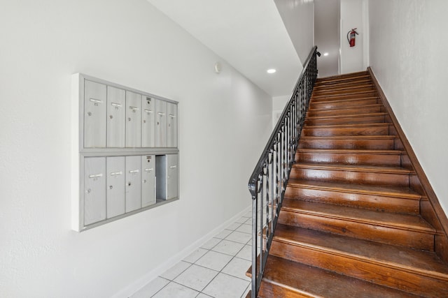 stairway featuring tile patterned flooring and a mail area