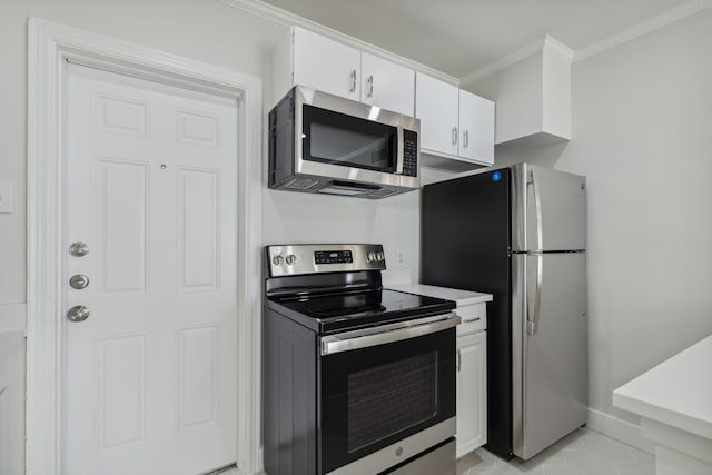 kitchen with ornamental molding, appliances with stainless steel finishes, and white cabinets