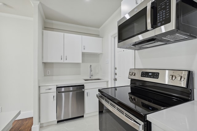 kitchen with stainless steel appliances, crown molding, sink, and white cabinets