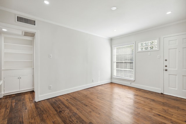 spare room featuring crown molding and dark wood-type flooring