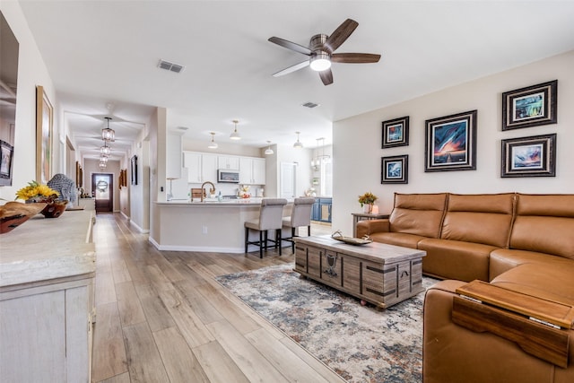 living room featuring ceiling fan and light wood-type flooring