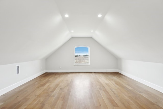 bonus room featuring lofted ceiling and light hardwood / wood-style flooring