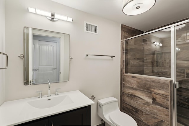 bathroom featuring an enclosed shower, vanity, and toilet