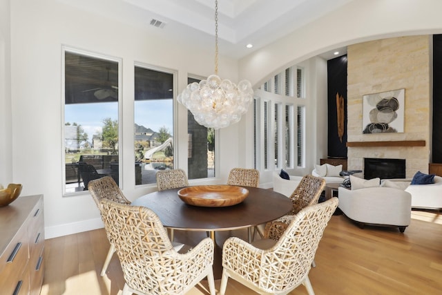 dining area featuring hardwood / wood-style floors, a notable chandelier, and a fireplace