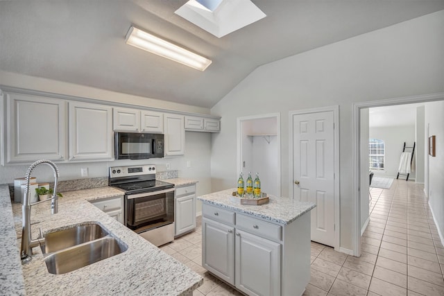 kitchen featuring sink, a center island, electric stove, vaulted ceiling with skylight, and light stone countertops