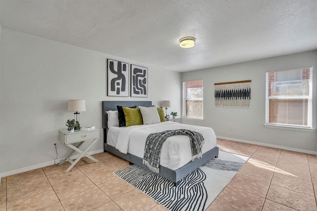 tiled bedroom featuring a textured ceiling