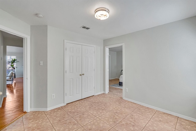 unfurnished bedroom with a closet and light tile patterned flooring