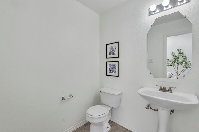 bathroom with sink, toilet, and tile patterned flooring