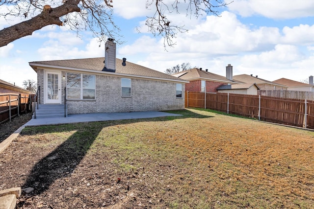 rear view of property featuring a lawn and a patio area