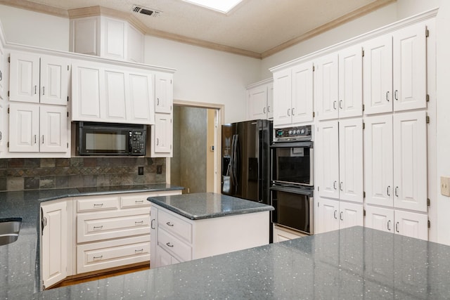 kitchen with white cabinetry, crown molding, dark stone countertops, a kitchen island, and black appliances