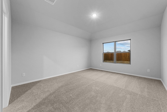 unfurnished room featuring vaulted ceiling and carpet