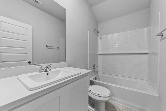 full bathroom with tiled shower / bath, vanity, and toilet