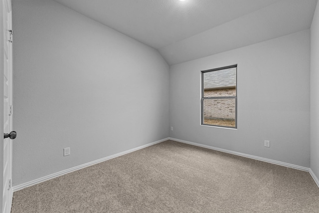 unfurnished room featuring lofted ceiling and carpet flooring