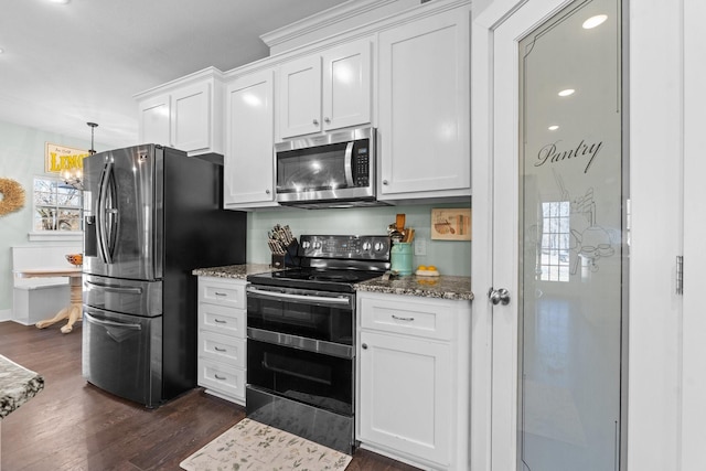 kitchen with stone countertops, white cabinetry, dark wood-style floors, and stainless steel appliances