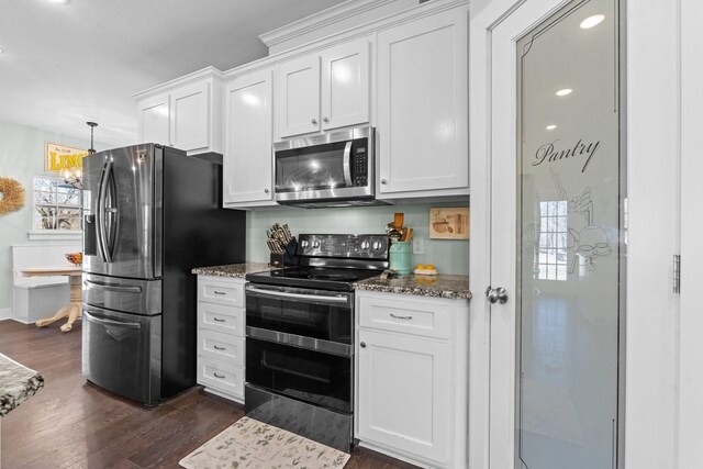 dining room featuring breakfast area, dark wood-type flooring, plenty of natural light, and an inviting chandelier