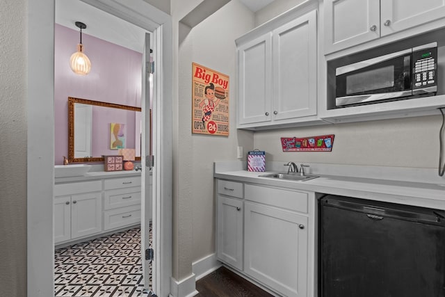 kitchen featuring a sink, light countertops, black dishwasher, and baseboards
