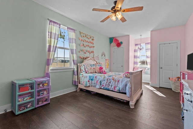 bedroom featuring dark wood-style floors, baseboards, multiple windows, and a ceiling fan