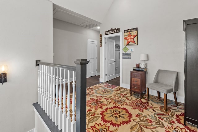 corridor with an upstairs landing, visible vents, baseboards, and lofted ceiling