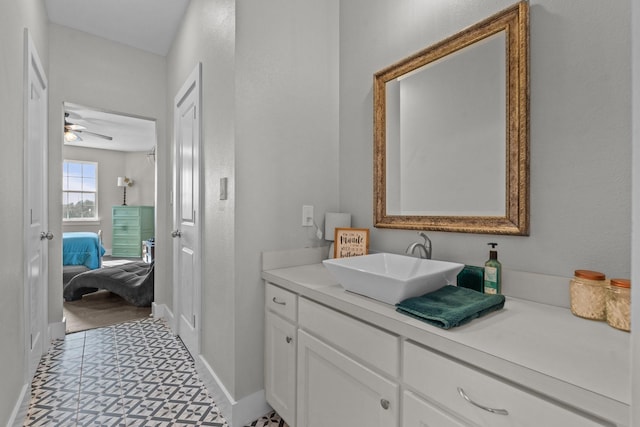 ensuite bathroom with ceiling fan, baseboards, vanity, and connected bathroom