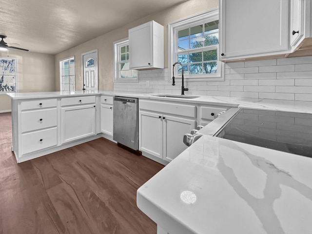 kitchen featuring white cabinetry, sink, stainless steel dishwasher, and kitchen peninsula